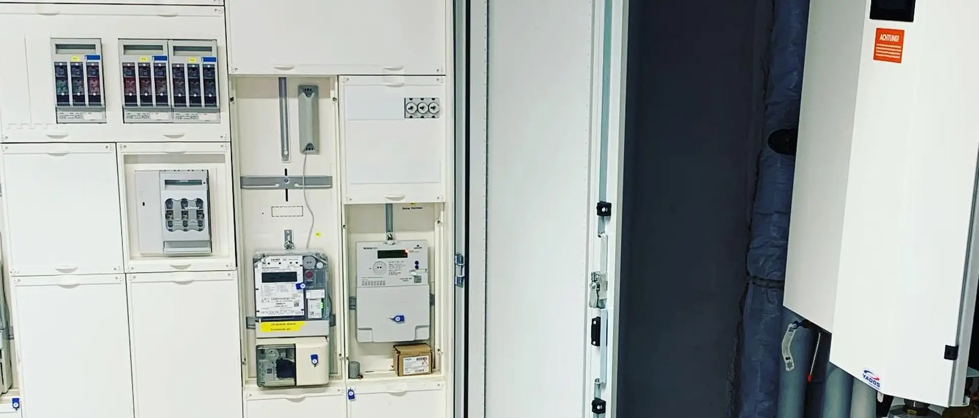 Elektroschaltschrank im Keller neben Heizungsanlage